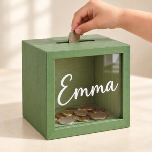 Child hand inserting a coin into the Emma bank